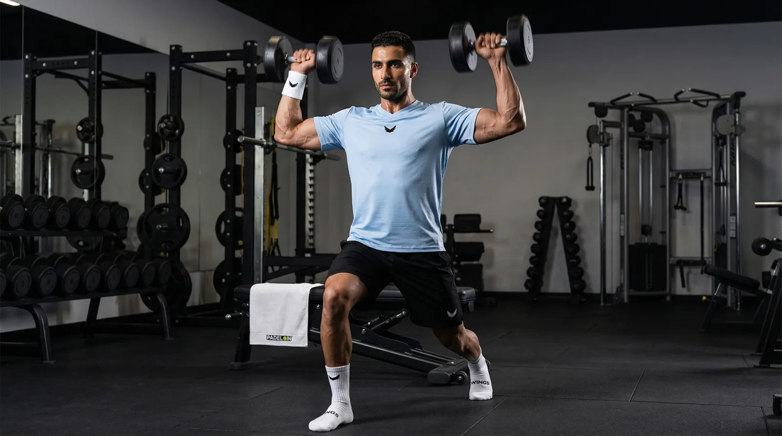 Athlete training with dumbbells in Wings sportswear
